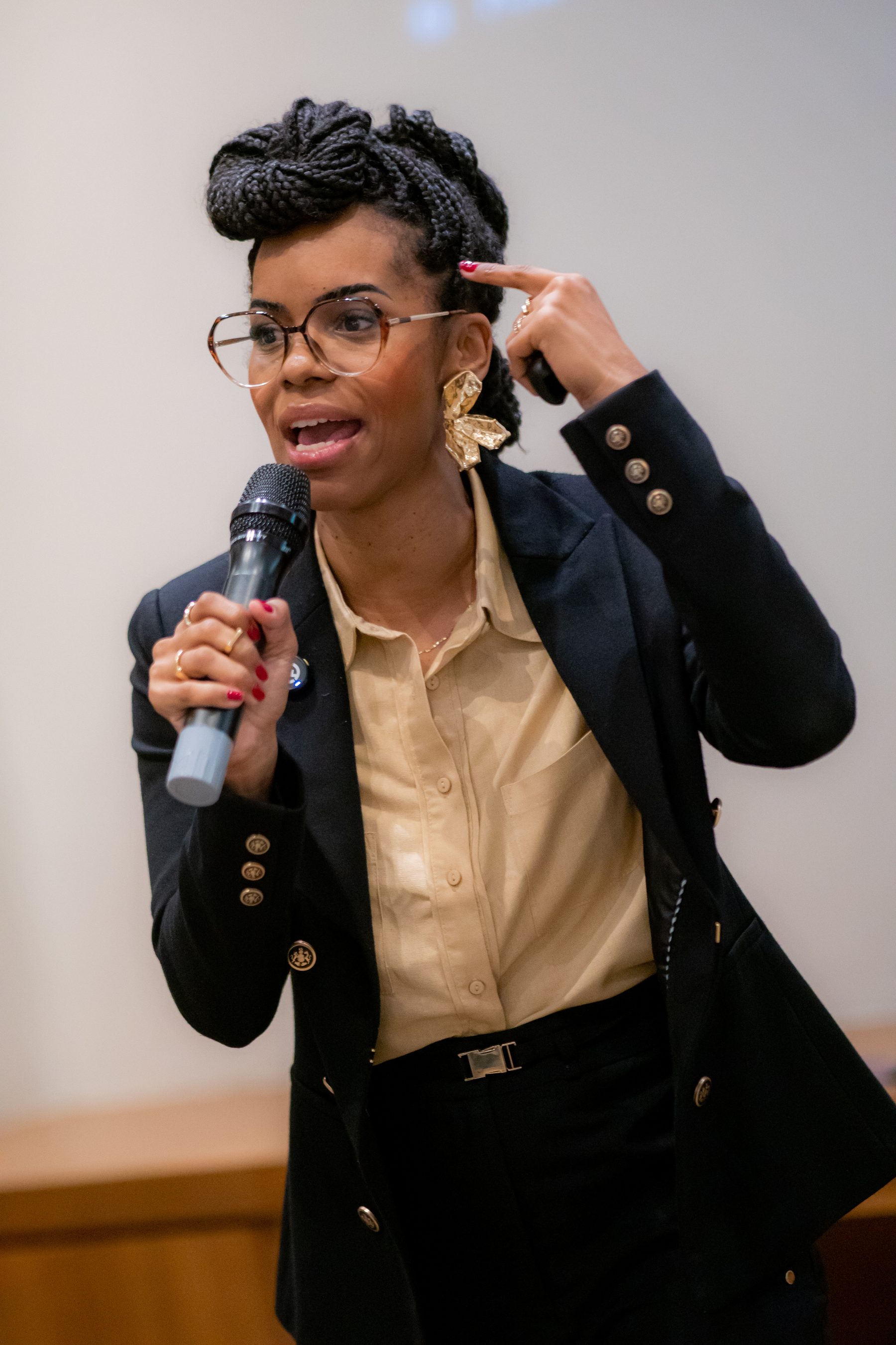 Thaís Floriano ao microfone durante palestra